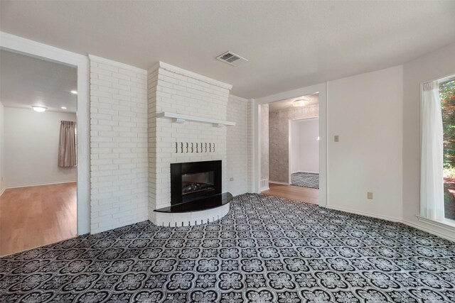 2508 Oak Manor Ct, Arlington, TX 76012 - unfurnished living room with a brick fireplace, wood finished floors, and baseboards