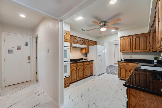 2508 Oak Manor Ct, Arlington, TX 76012 - kitchen with white appliances, light marble finish floors, brown cabinetry, baseboards, and recessed lighting