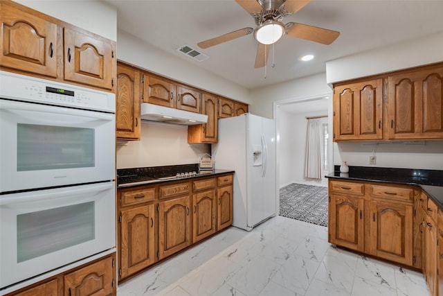2508 Oak Manor Ct, Arlington, TX 76012 - kitchen with white appliances, under cabinet range hood, brown cabinetry, and recessed lighting