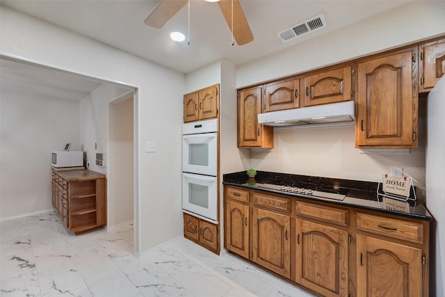 2508 Oak Manor Ct, Arlington, TX 76012 - kitchen with white appliances, under cabinet range hood, light marble finish flooring, and brown cabinets