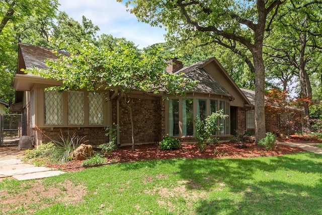 2508 Oak Manor Ct, Arlington, TX 76012 - view of front facade featuring brick siding, a chimney, a front yard, and roof with shingles