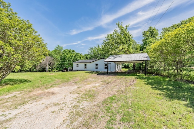 238 Briar Oaks Dr, Azle, TX 76020 - view of green lawn with driveway, a detached carport, and view of scattered trees