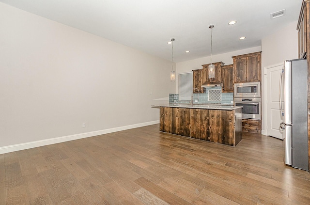 413 Allbright Rd, Celina, TX 75009 - kitchen featuring stainless steel appliances, wood finished floors, backsplash, recessed lighting, and an island with sink