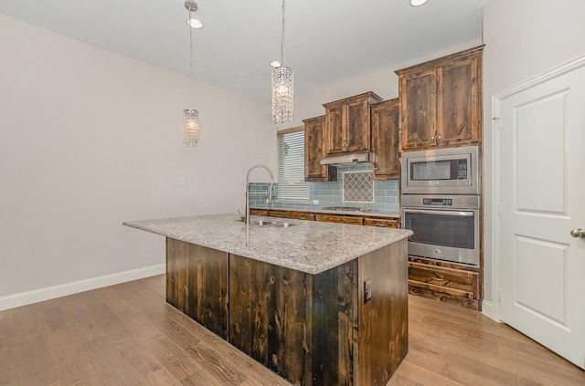 413 Allbright Rd, Celina, TX 75009 - kitchen featuring stainless steel appliances, a sink, light wood-style floors, tasteful backsplash, and light stone counters