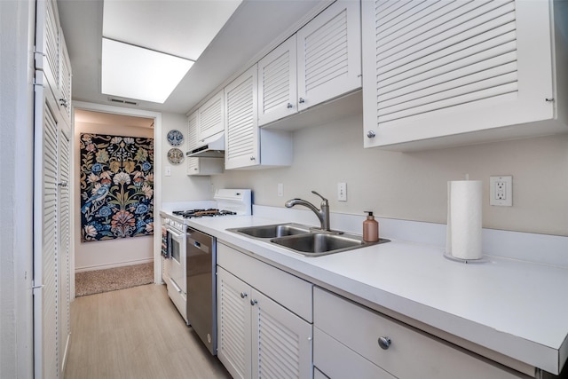 kitchen with a sink, under cabinet range hood, dishwasher, white gas stove, and light countertops