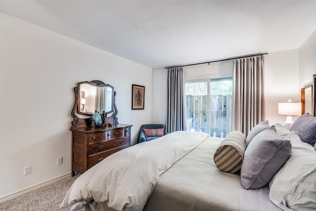 bedroom with baseboards, carpet floors, and access to outside