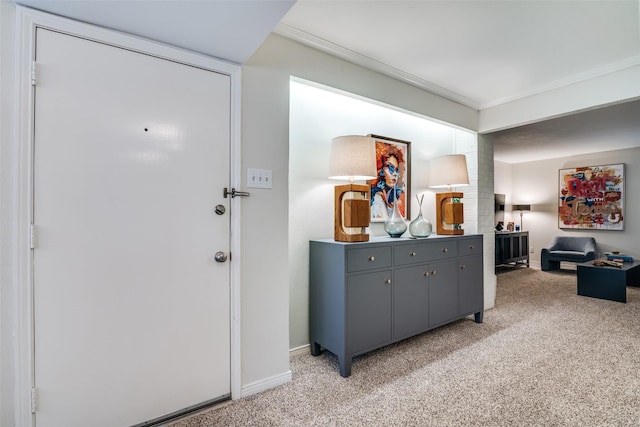 foyer entrance with light carpet, crown molding, and baseboards