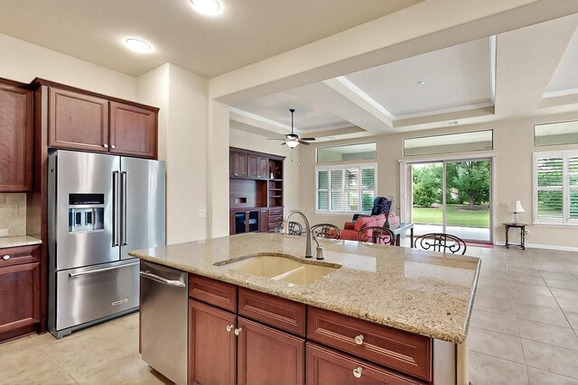 11908 Glenbrook St, Denton, TX 76207 - kitchen featuring stainless steel appliances, a sink, a ceiling fan, a kitchen island with sink, and light stone counters