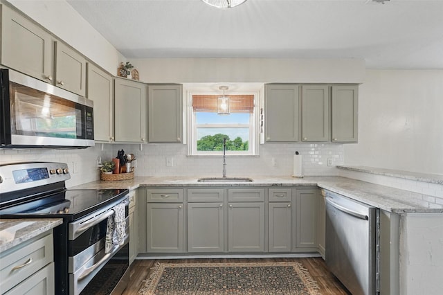 205 Davis Rd, Combine, TX 75159 - kitchen featuring appliances with stainless steel finishes, a sink, gray cabinets, dark wood-style floors, and backsplash
