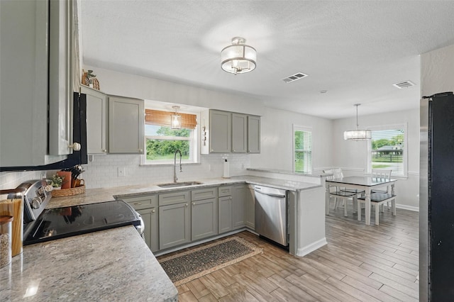 205 Davis Rd, Combine, TX 75159 - kitchen featuring a sink, stainless steel appliances, a peninsula, decorative backsplash, and gray cabinetry