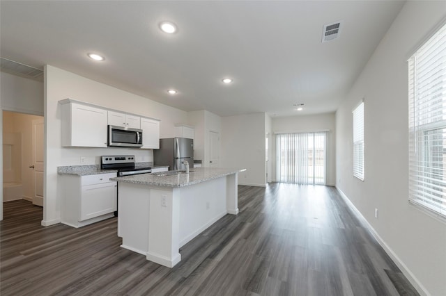 6303 Tropicana Ln, Forney, TX 75126 - kitchen with appliances with stainless steel finishes, dark wood-style flooring, an island with sink, a sink, and white cabinets