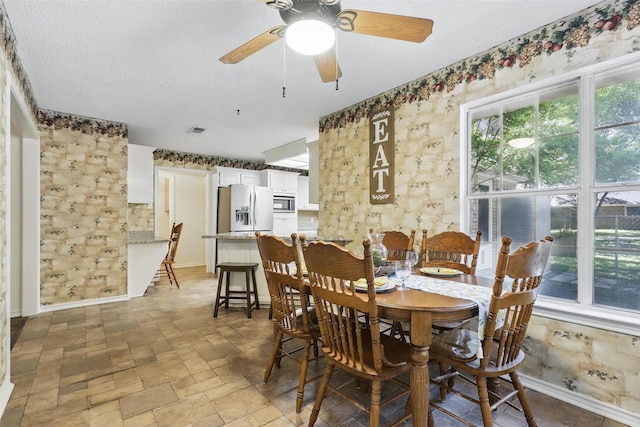 221 Valley Ranch Rd, Weatherford, TX 76087 - dining space featuring ceiling fan, stone finish floors, and a textured ceiling