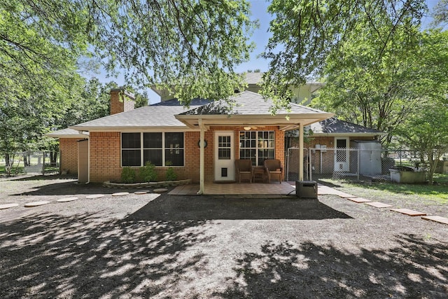 221 Valley Ranch Rd, Weatherford, TX 76087 - back of house with a gate, brick siding, a chimney, and a shingled roof