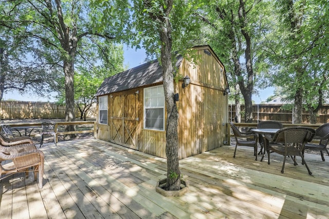 221 Valley Ranch Rd, Weatherford, TX 76087 - wooden deck featuring outdoor dining area, a fenced backyard, and an outbuilding