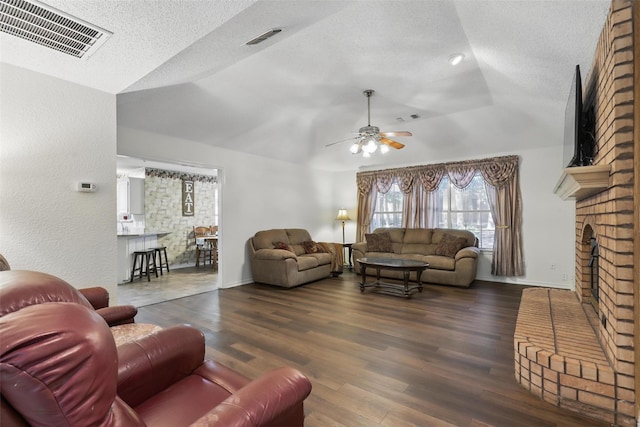 221 Valley Ranch Rd, Weatherford, TX 76087 - living room with vaulted ceiling, a ceiling fan, a textured ceiling, a brick fireplace, and wood finished floors