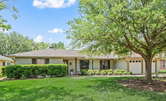 ranch-style house with a garage, a front yard, brick siding, and a chimney