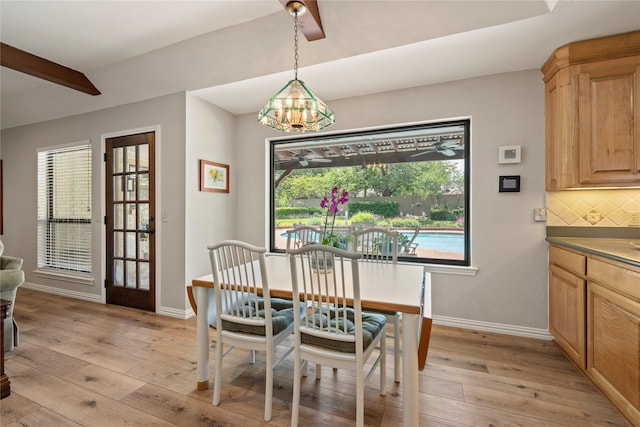 dining space with light wood-type flooring, baseboards, and a chandelier