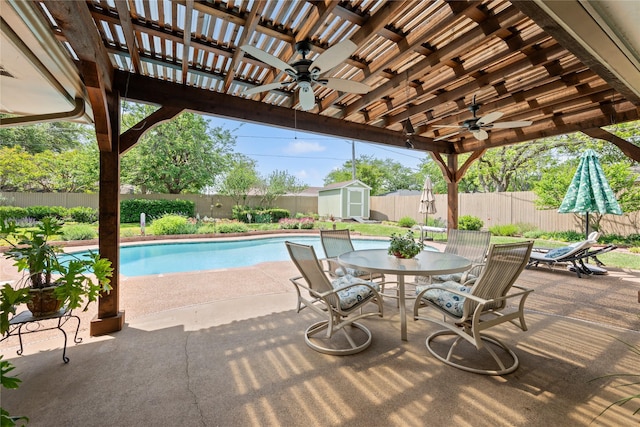 view of pool featuring a ceiling fan, a shed, outdoor dining area, and a fenced backyard