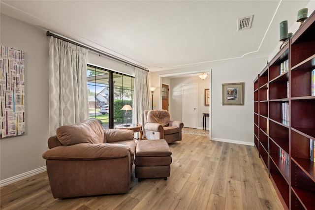 sitting room featuring light wood-type flooring and baseboards