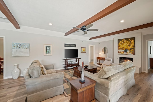 living room featuring beam ceiling, a ceiling fan, light wood-style flooring, baseboards, and recessed lighting