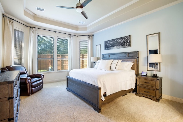 carpeted bedroom featuring ornamental molding, a raised ceiling, baseboards, and a ceiling fan