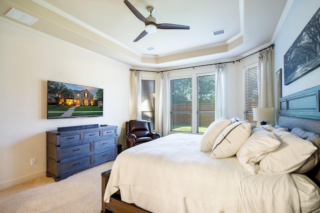 bedroom with a raised ceiling, light colored carpet, crown molding, a ceiling fan, and baseboards