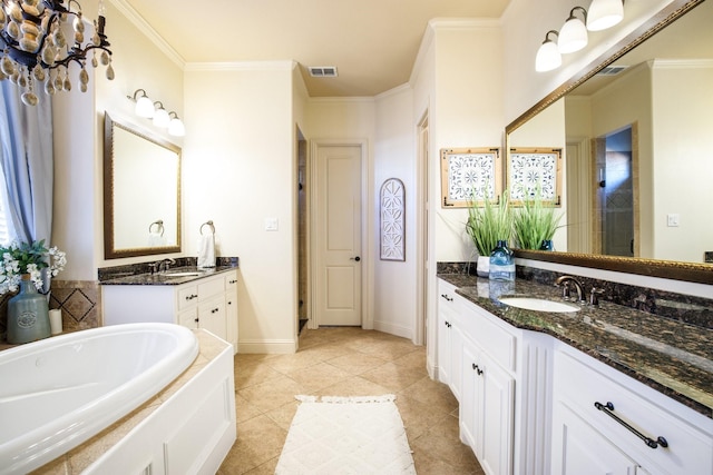 bathroom with a bath, ornamental molding, two vanities, tile patterned flooring, and baseboards