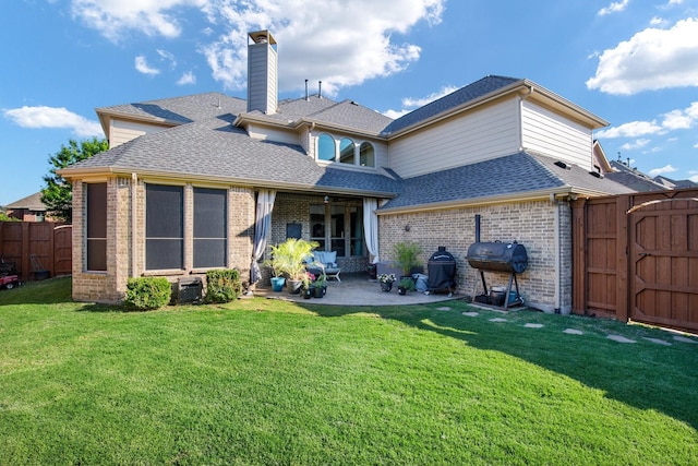 back of house featuring brick siding, a patio area, a chimney, and a shingled roof
