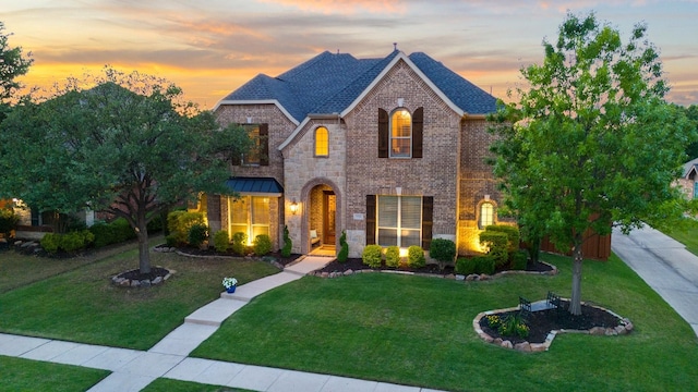 french country home with brick siding and a front lawn