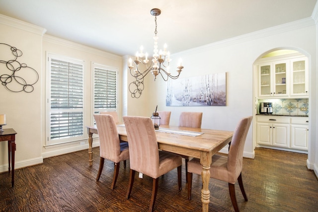 dining room featuring a chandelier, dark wood-type flooring, ornamental molding, and baseboards