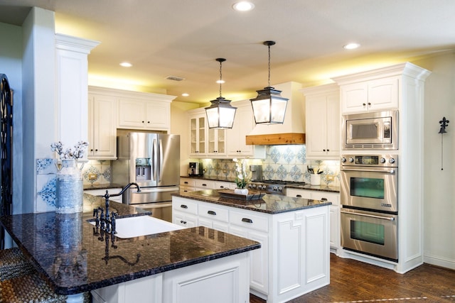 kitchen with appliances with stainless steel finishes, a peninsula, decorative backsplash, glass insert cabinets, and recessed lighting