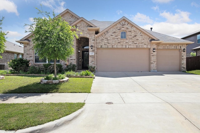 1127 Donnington Trl, Saginaw, TX 76131 - french country home with an attached garage, concrete driveway, a front lawn, and brick siding