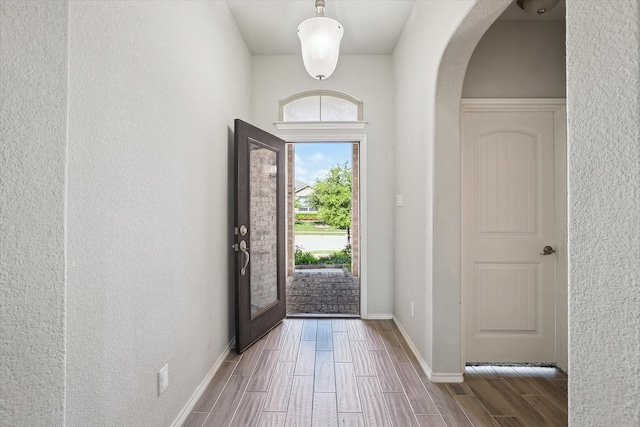 1127 Donnington Trl, Saginaw, TX 76131 - foyer entrance featuring arched walkways, wood tiled floors, baseboards, and a textured wall