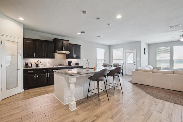 1127 Donnington Trl, Saginaw, TX 76131 - kitchen with a sink, a breakfast bar, open floor plan, tasteful backsplash, and a center island with sink