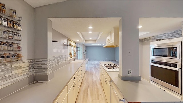 2810 Dove Meadow Dr, Garland, TX 75043 - kitchen featuring stainless steel appliances, light wood-style floors, tasteful backsplash, light countertops, and open shelves