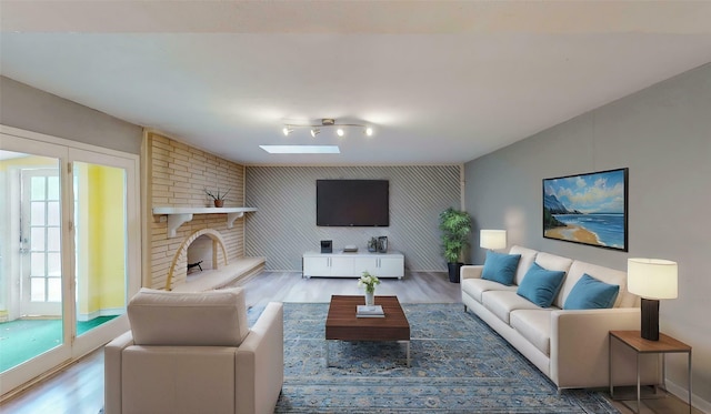 2810 Dove Meadow Dr, Garland, TX 75043 - living room with wood finished floors, an accent wall, a fireplace, and a skylight