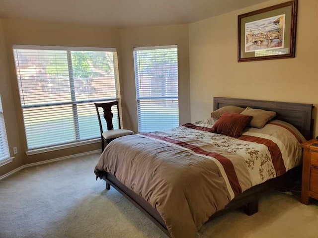 bedroom with light carpet and baseboards