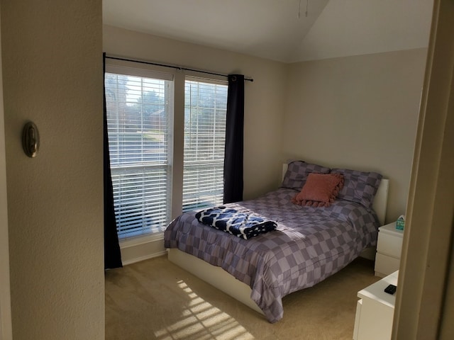 bedroom with vaulted ceiling, carpet floors, and baseboards