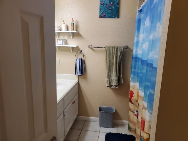 bathroom featuring tile patterned flooring, vanity, baseboards, and a shower with shower curtain