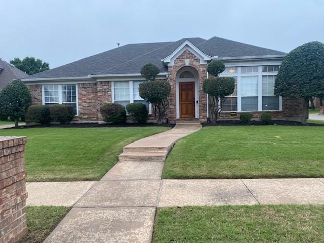 view of front of house featuring a front lawn and brick siding