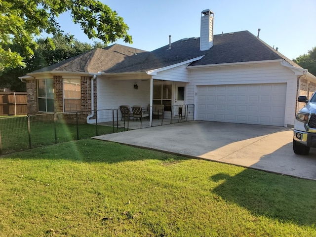rear view of property with a garage, a chimney, concrete driveway, and roof with shingles
