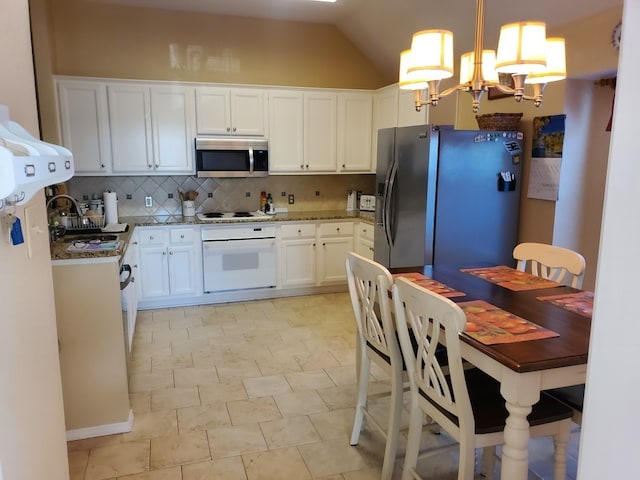 kitchen featuring stainless steel appliances, a sink, a chandelier, decorative backsplash, and white cabinetry