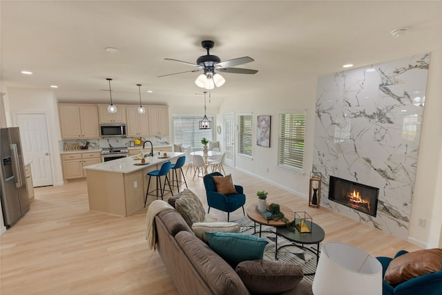 9716 Meadow Creek Dr, Denton, TX 76226 - living area featuring light wood-type flooring, a fireplace, recessed lighting, ceiling fan, and baseboards