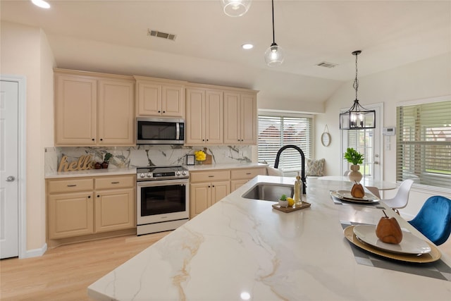 9716 Meadow Creek Dr, Denton, TX 76226 - kitchen with stainless steel appliances, a sink, hanging light fixtures, light wood-type flooring, and decorative backsplash
