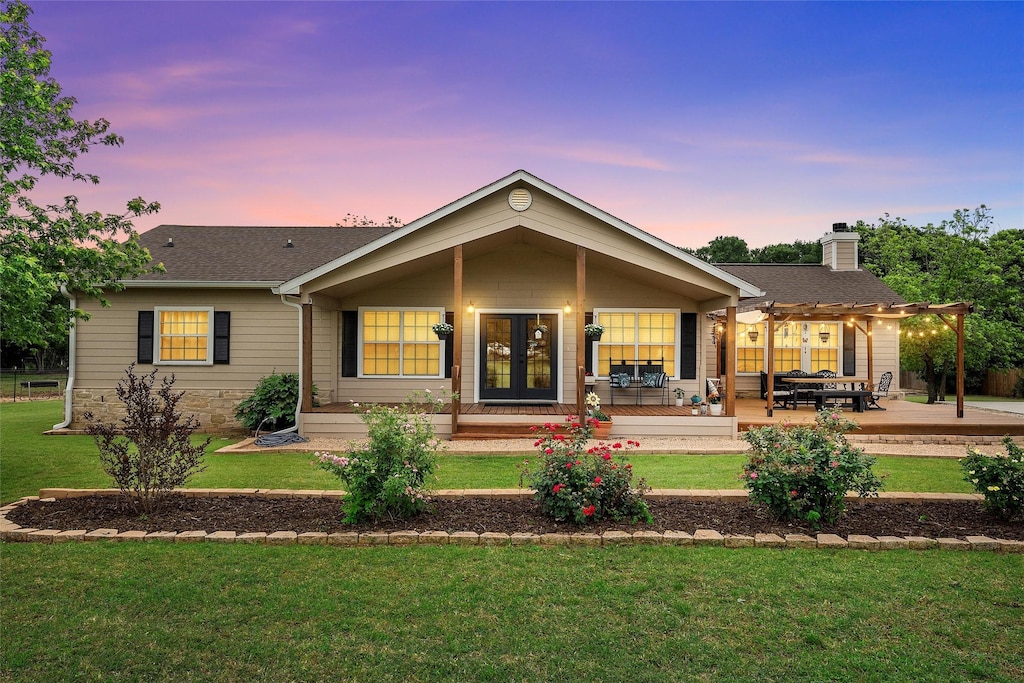 back of property featuring a pergola, a lawn, and a shingled roof
