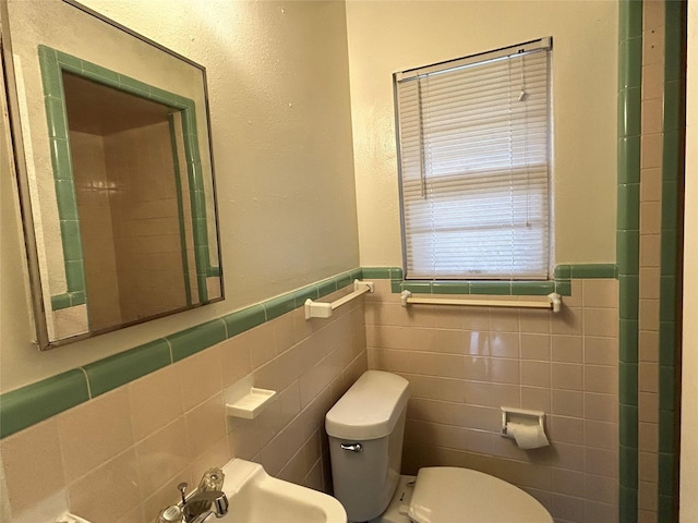 5004 Haywood Pkwy, Dallas, TX 75232 - bathroom featuring tile walls, toilet, and wainscoting