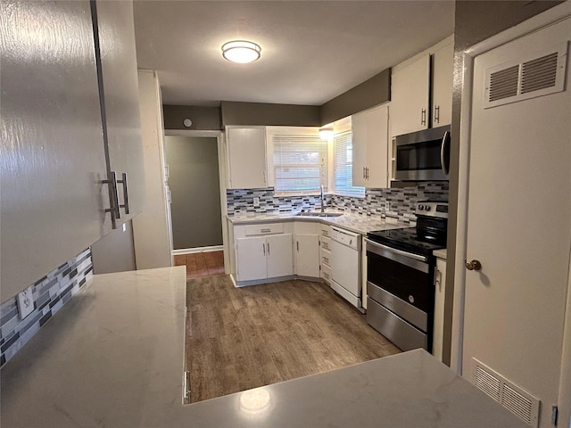 5004 Haywood Pkwy, Dallas, TX 75232 - kitchen with appliances with stainless steel finishes, a sink, tasteful backsplash, and white cabinets