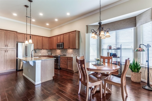11708 Southerland Dr, Denton, TX 76207 - kitchen featuring appliances with stainless steel finishes, crown molding, an island with sink, light stone counters, and brown cabinetry