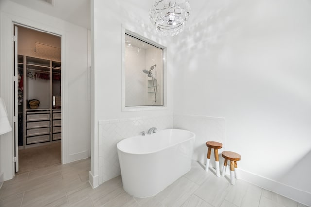 1908 St Andrews Dr, Celina, TX 75009 - bathroom with a spacious closet, a shower, a freestanding bath, and wainscoting