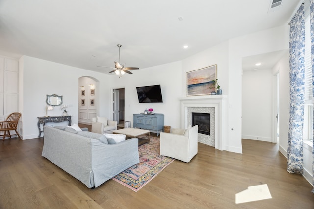1908 St Andrews Dr, Celina, TX 75009 - living area featuring arched walkways, wood finished floors, a ceiling fan, a fireplace, and recessed lighting